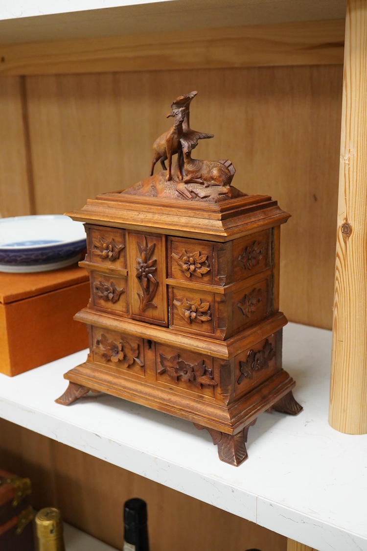 A 20th century black forest carved wood jewellery box, surmounted with two deer, 28cm high